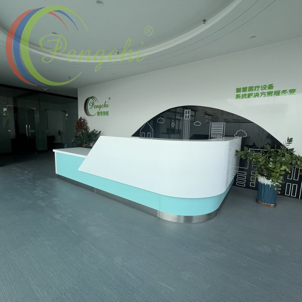 Hall d'accueil d'entreprise moderne et lumineux, articulé autour d'un élégant comptoir de réception courbé doté d'un habillage supérieur blanc lisse, d'une garniture inférieure turquoise pâle et douce et d'un bord en acier inoxydable brossé, le tout posé sur un revêtement de sol commercial texturé gris discret. Derrière le comptoir, un mur d'accent blanc mat présente le logo coloré de la marque Pengchi à gauche, ainsi qu'un texte chinois vert en relief identifiant l'entreprise comme un fournisseur de solutions de systèmes d'équipements médicaux intelligents en haut à droite. Une découpe murale courbée révèle un fond noir brillant orné d'un dessin au trait blanc minimaliste représentant des bâtiments urbains et des nuages. De luxuriantes plantes vertes brillantes en pot encadrent le comptoir, l'une dans un pot bleu foncé texturé au coin droit, tandis que des cloisons en verre teinté sans cadre et des portes à poignées argentées bordent l'espace sous un éclairage plafonnier neutre et uniforme.
