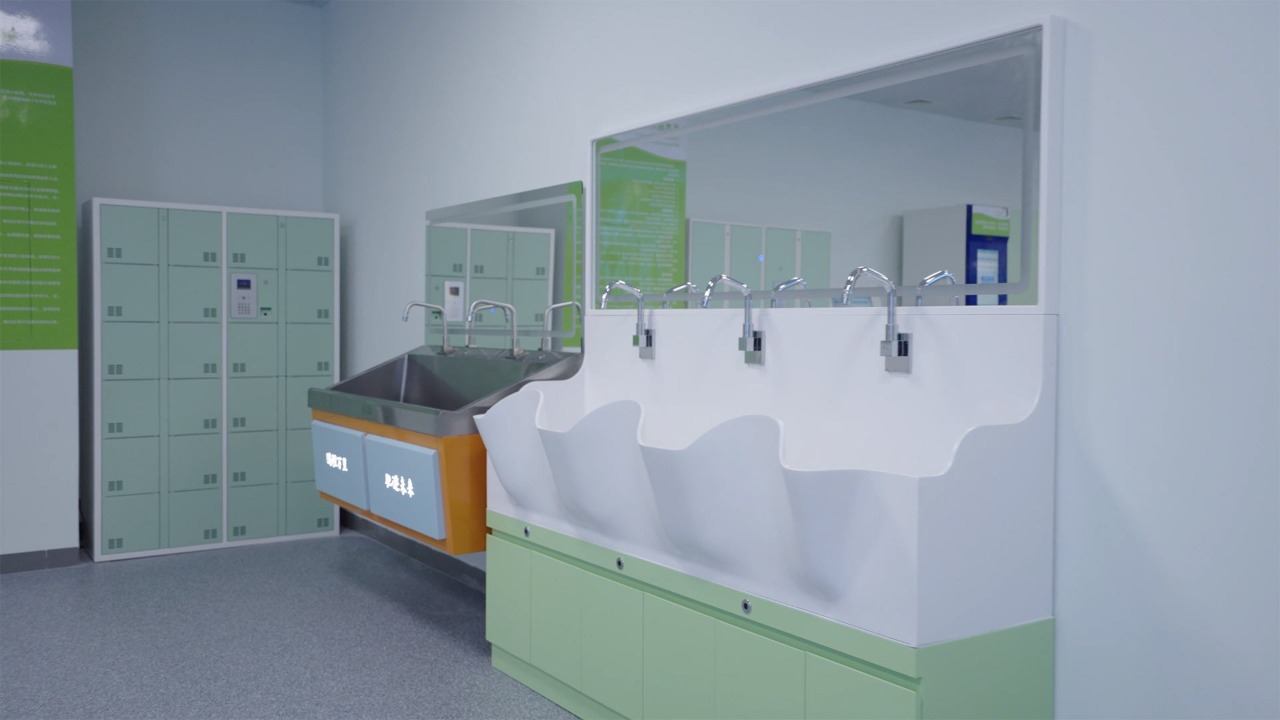 Sala de lavado quirúrgico de hospital con lavamanos quirúrgicos de múltiples cubetas en forma de onda, grifos de cuello de cisne cromados y espejos grandes